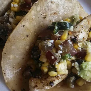 Swai fish tacos topped with roasted corn - poblano pepper and red grape relish!