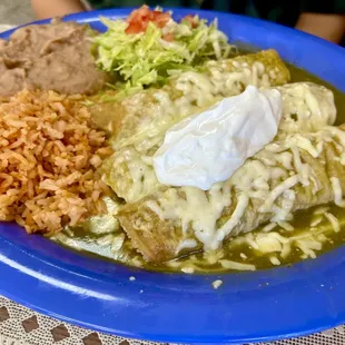 Enchiladas Suizas with shredded chicken &amp;  cheese, covered in verde sauce &amp; sour cream with refried beans and rice!