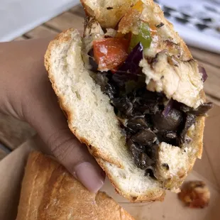 a hand holding a sandwich