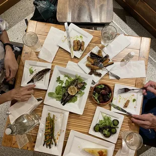 people sitting at a table with plates of food