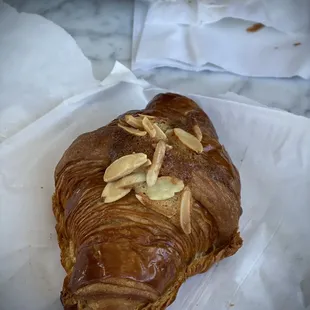 Croissant aux amandes NUTS. butter croissant with almond cream and sliced toasted almonds on top