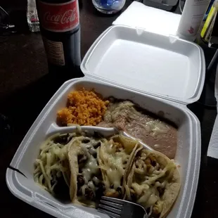 Two chicken tacos two carne asada tacos and some rice and beans