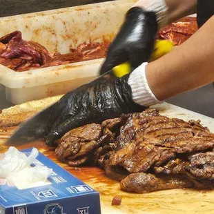 a person cutting meat on a cutting board