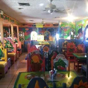 brightly colored tables and chairs in a brightly decorated restaurant