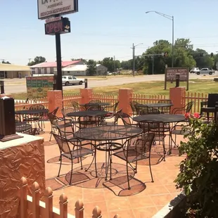a patio area with tables and chairs