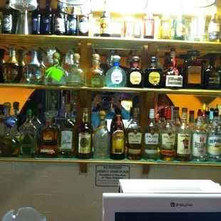a shelf full of liquor bottles