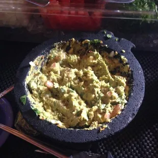 a bowl of guacamole with chopsticks