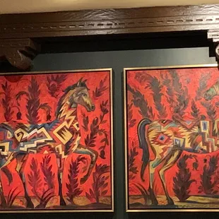 a man sitting in front of two paintings