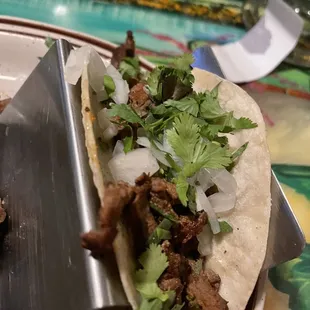 a taco with meat and lettuce