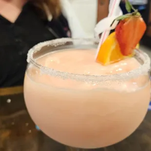 a woman sitting at a table with a drink