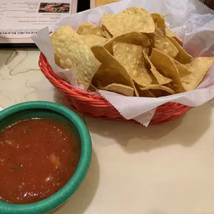 a basket of chips and a bowl of salsa