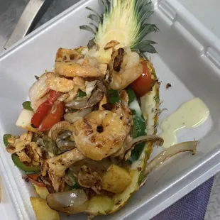 a pineapple with shrimp and vegetables
