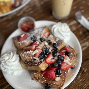 a plate of french toast with strawberries and blueberries