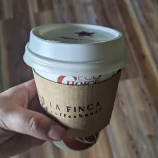 a hand holding a coffee cup