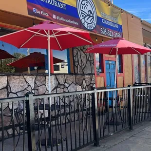 the outside of a restaurant with tables and umbrellas