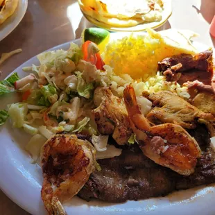 Combination plate. Steak,chorizo ,chicken and shrimp. Rice,beans,salad and tortillas.