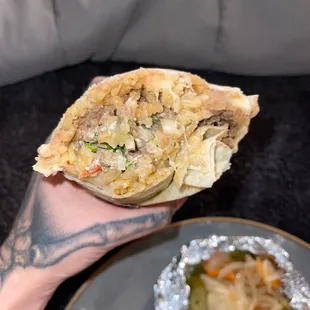 a person holding a burrito