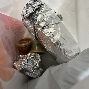 a sandwich wrapped in aluminum foil