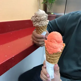 a man holding two ice cream cones