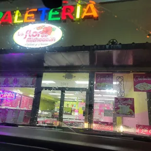 a neon sign above a storefront