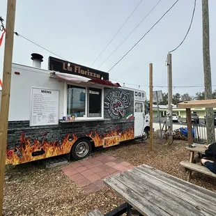 a man sitting on a bench in front of a food truck