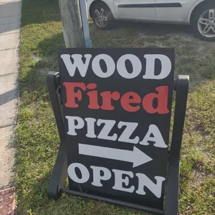 a wood fired pizza open sign