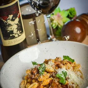 a bowl of pasta and a glass of wine