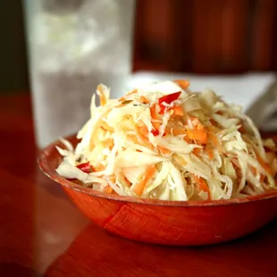 a bowl of sauerkraut and a glass of water