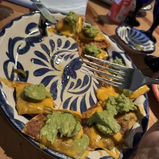 a plate of nachos with guacamole