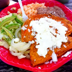Enchiladas potosinas with pickled piggie skins (that&apos;s the white strips that look like onions).