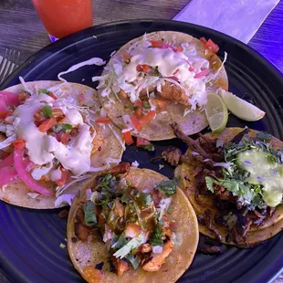 Starting at the left and going clockwise: La Fogata Taco, Fish Taco, al pastor taco, chicken taco. 16 oz michelada in the back