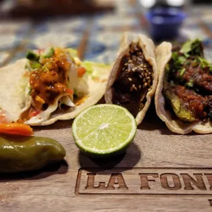 Taco trio with fish taco, arrachera, and mole poblano taco.