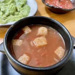 a bowl of soup and a plate of guacamole