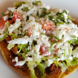 a taco with lettuce and tomatoes