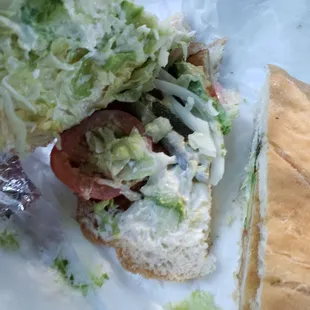 a sandwich with lettuce and tomatoes