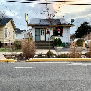 a street corner with a house in the background