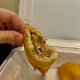a hand holding a half of a sandwich