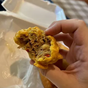 a hand holding a piece of food