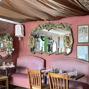 a dining area with pink booths and tables