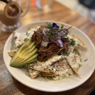 Chilaquiles en salsa verde con birria (super good) Cafe de la olla in the background (to die for)