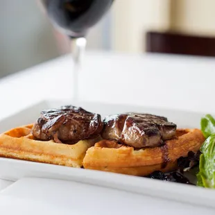 a plate of food and a glass of wine