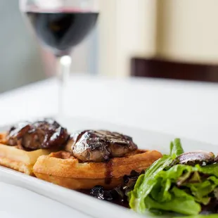 a plate of food and a glass of wine