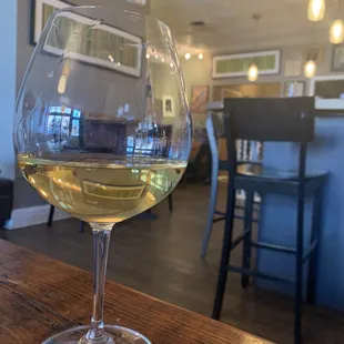 a glass of white wine on a table