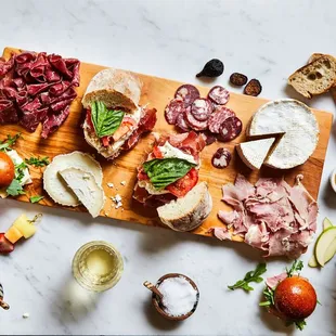 a platter of meats, bread, and vegetables