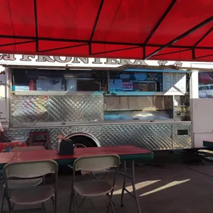 a food truck with tables and chairs