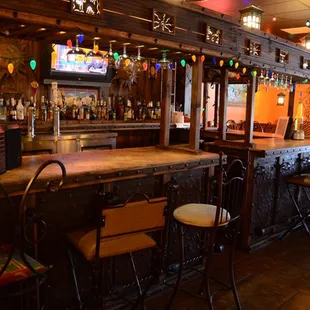 a bar with chairs and a television