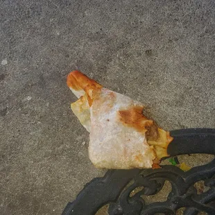 a piece of pizza on a bench