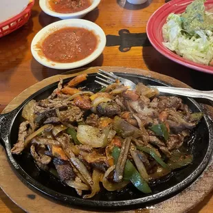 Steak fajitas with rice, beans and tortillas.