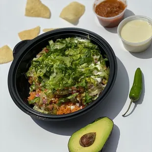 a bowl of guacamole, tortilla, and avocado