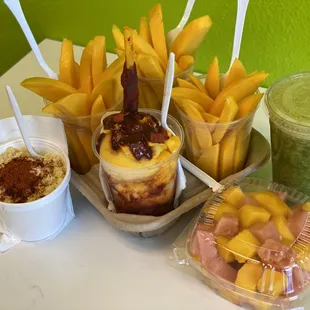 Plain mango cups, natural handmade mango icecream with our special sour sauce, green juice, corn in a cup and chopped mango with watermelon.